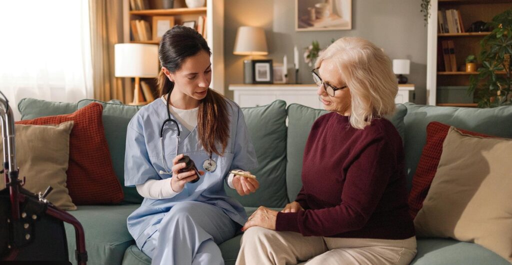 home health nurse assisting senior woman with medicanation - clm community services bundaberg